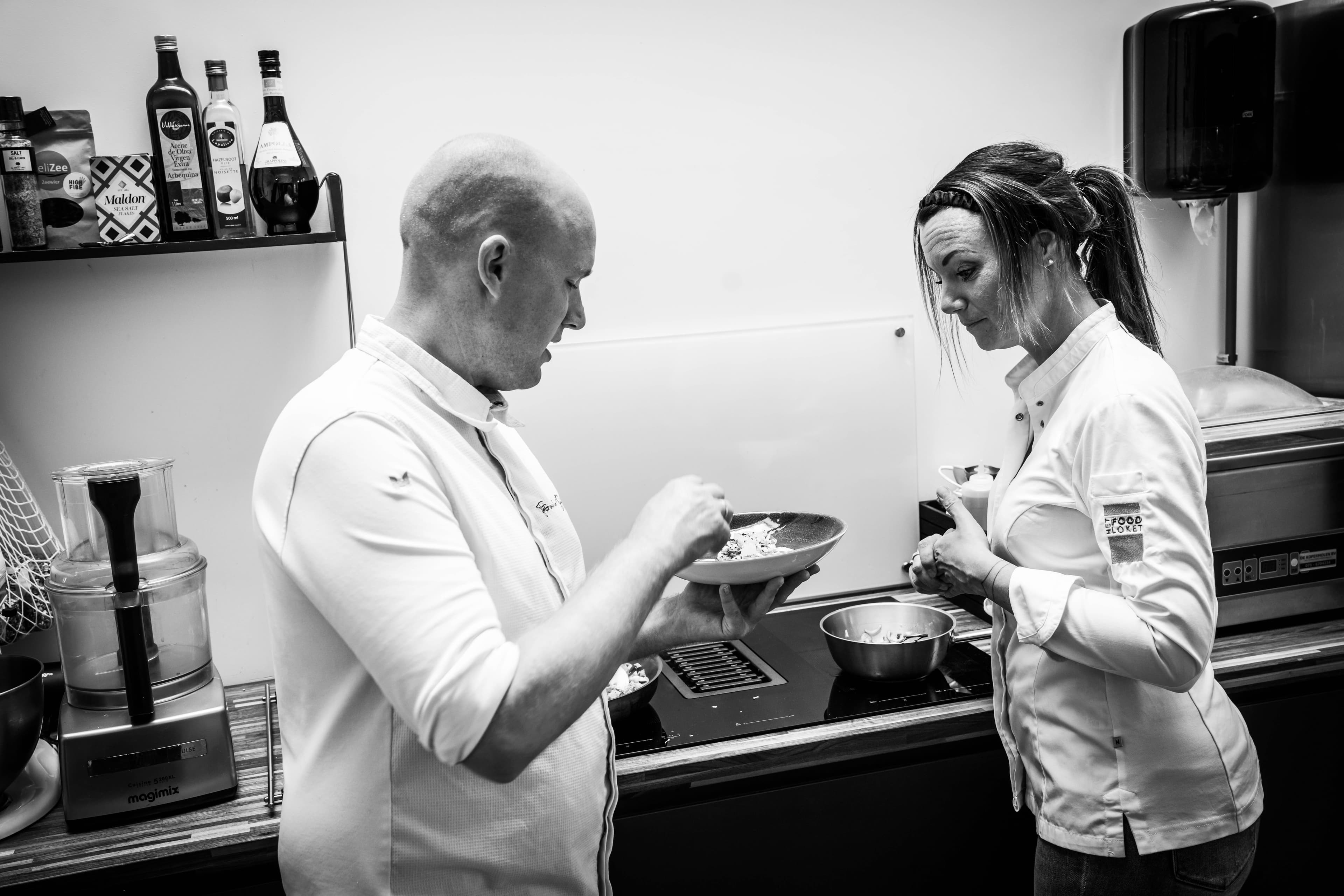 Two chefs taste together during a cooking workshop at De Proefklas